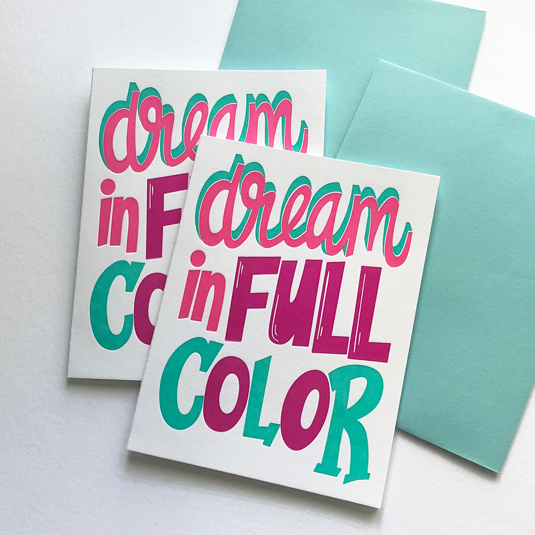 Two greeting cards in pink, purple and blue with two blue envelopes and teh words dream in full color